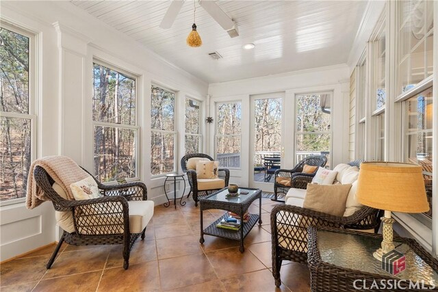 sunroom featuring visible vents, crown molding, and tile patterned floors
