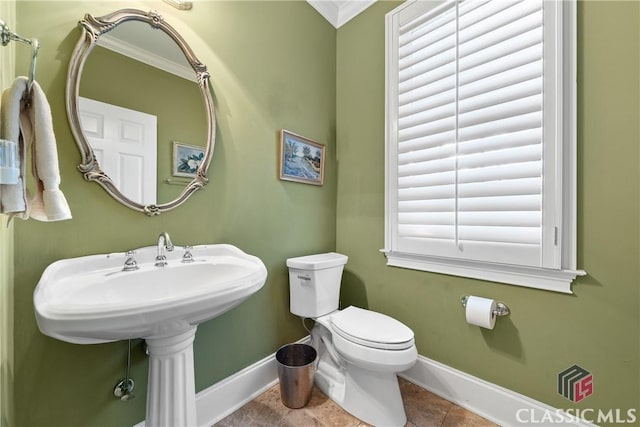 half bathroom featuring baseboards, ornamental molding, tile patterned floors, and toilet