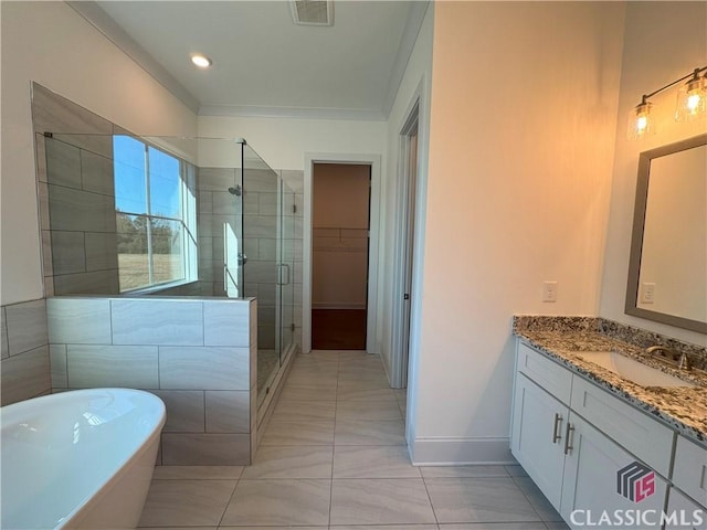 full bathroom with a walk in closet, a soaking tub, visible vents, a stall shower, and vanity