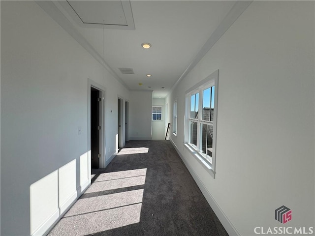 corridor featuring attic access, carpet, visible vents, and baseboards