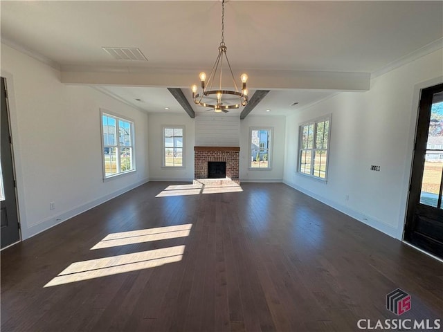 unfurnished living room featuring baseboards, visible vents, dark wood-style flooring, a brick fireplace, and a chandelier