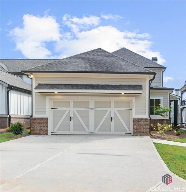 1380 Melody Bnd Unit 45, Watkinsville, GA 30677 - view of front of house featuring concrete driveway, brick siding, an attached garage, and a shingled roof