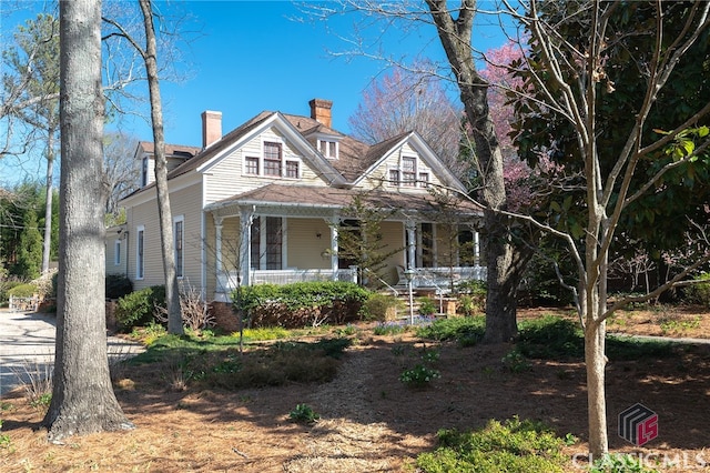 view of front of home with covered porch and a chimney