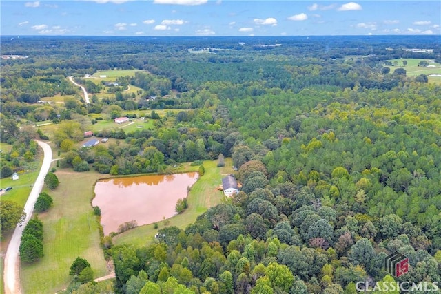 drone / aerial view with a water view and a forest view