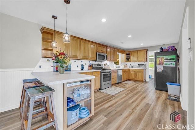 kitchen featuring open shelves, stainless steel appliances, light countertops, light wood-style floors, and a peninsula