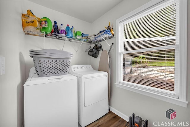 laundry area with laundry area, baseboards, washer and dryer, and wood finished floors