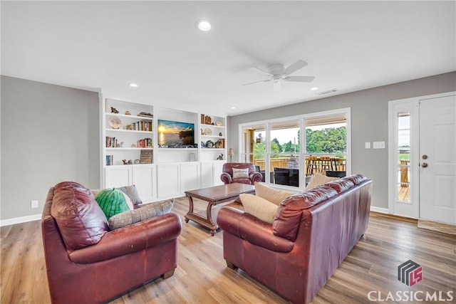 living room with light wood-type flooring, baseboards, visible vents, and recessed lighting