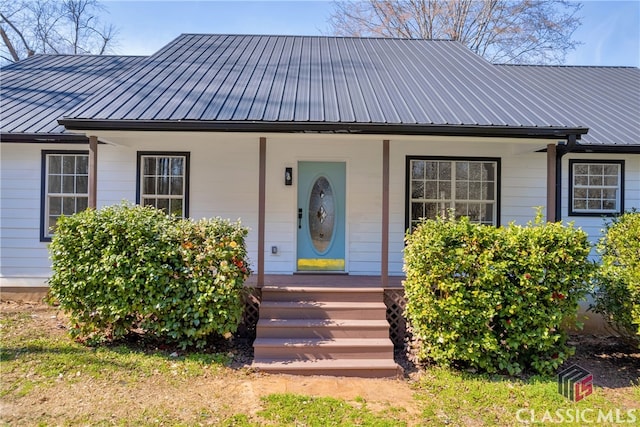 bungalow with covered porch, metal roof, and a standing seam roof