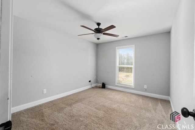 empty room featuring a ceiling fan, carpet flooring, visible vents, and baseboards