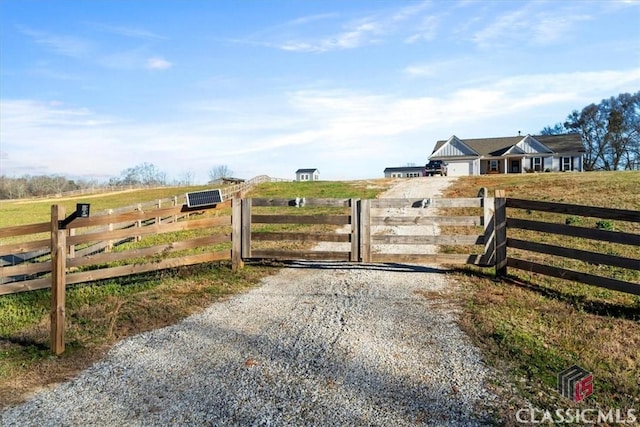 view of gate with a rural view and fence