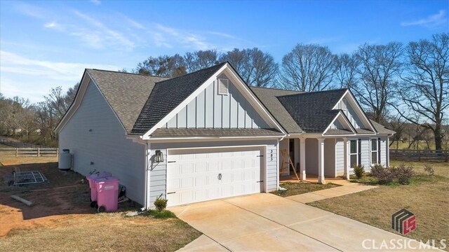 view of front of home with covered porch, driveway, board and batten siding, and an attached garage