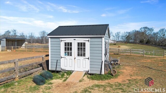 view of outdoor structure with an outbuilding and fence