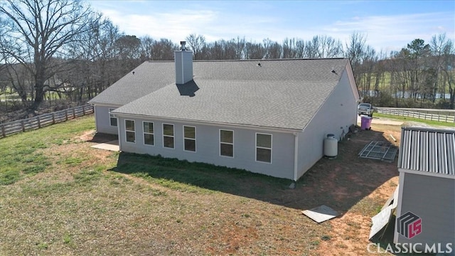 exterior space with fence, a chimney, and a lawn