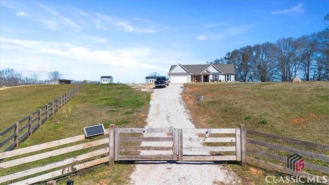 exterior space with a rural view, a fenced front yard, and a lawn