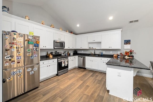 kitchen with stainless steel appliances, a peninsula, visible vents, and white cabinets