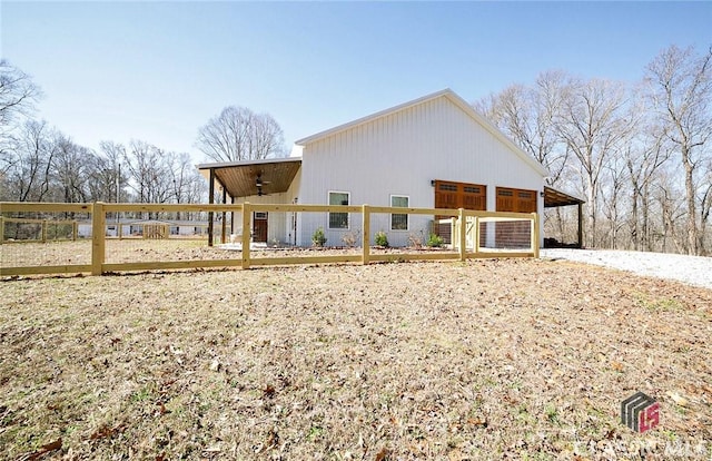 rear view of house featuring ceiling fan and an outdoor structure