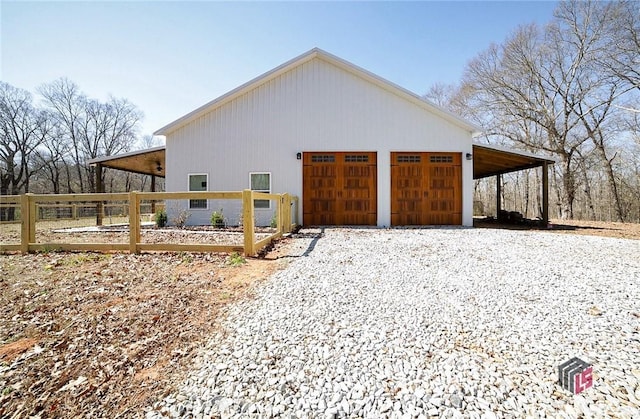 garage with fence and driveway