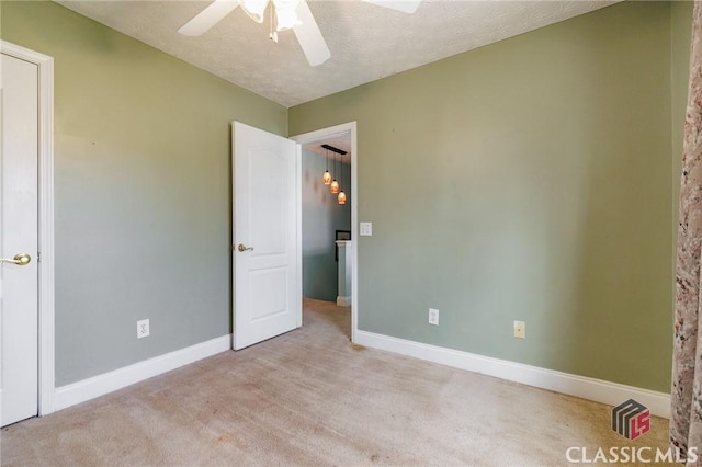 unfurnished bedroom with a ceiling fan, a textured ceiling, baseboards, and carpet flooring