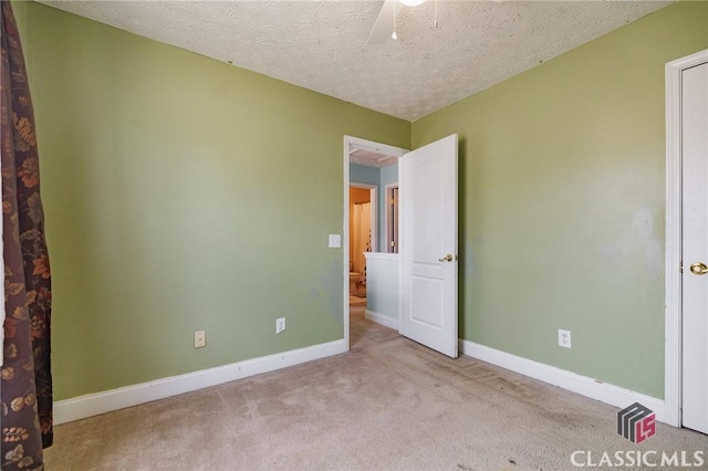 unfurnished bedroom featuring a textured ceiling, carpet flooring, and baseboards