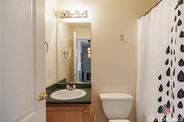 full bath with a shower with curtain, vanity, and toilet