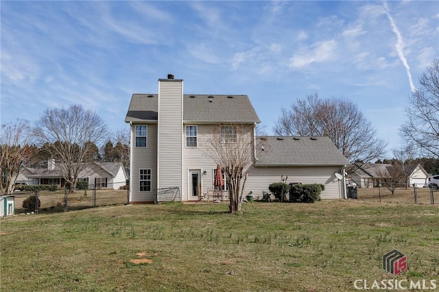 rear view of property with a shingled roof, a chimney, fence, and a lawn