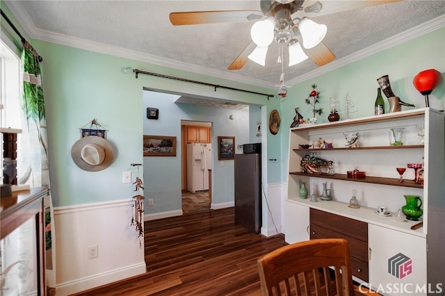 dining area featuring dark wood-style floors, crown molding, ceiling fan, a textured ceiling, and baseboards