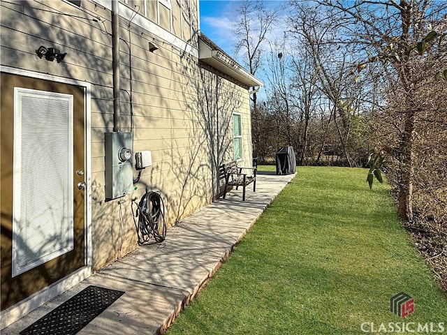 view of side of home with a yard