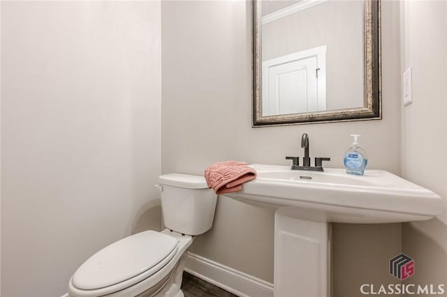 bathroom with baseboards and toilet