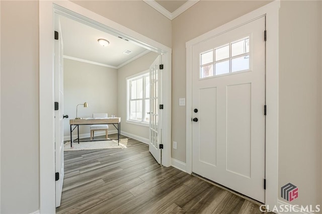 foyer featuring baseboards, crown molding, and wood finished floors