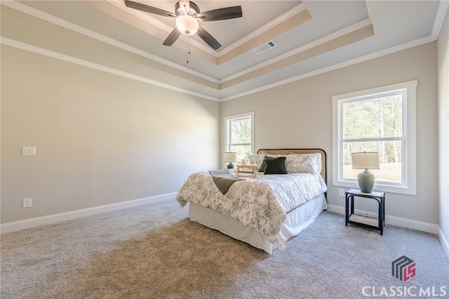 bedroom with baseboards, crown molding, visible vents, a raised ceiling, and light colored carpet