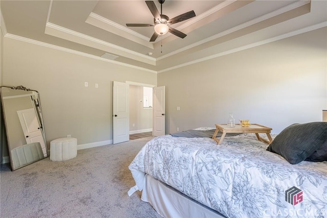 bedroom featuring crown molding, a tray ceiling, and carpet floors
