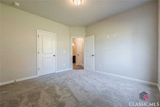 unfurnished bedroom with carpet flooring and baseboards