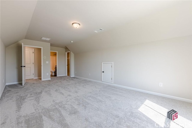 additional living space featuring visible vents, baseboards, light carpet, and lofted ceiling
