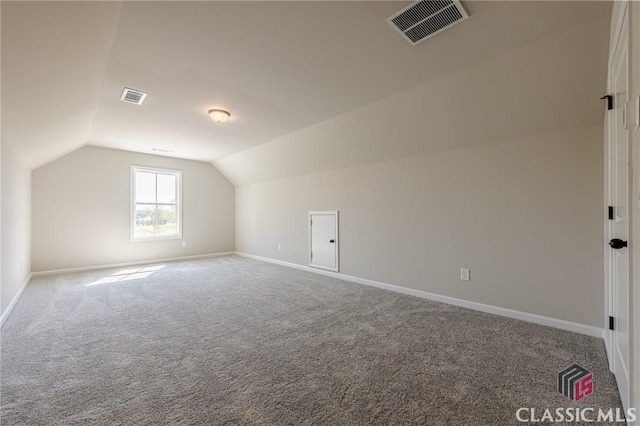 additional living space featuring carpet, visible vents, baseboards, and vaulted ceiling
