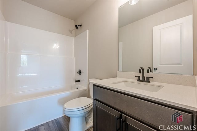 full bath featuring vanity, wood finished floors, toilet, and tub / shower combination