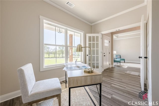 home office with visible vents, baseboards, ornamental molding, and wood finished floors