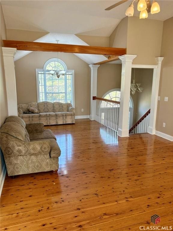 living room featuring hardwood / wood-style floors, plenty of natural light, and ornate columns