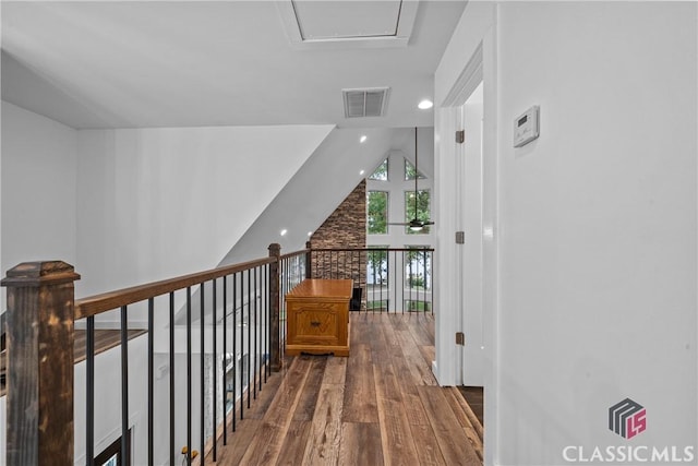 hall featuring lofted ceiling, visible vents, and wood finished floors