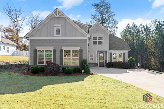 craftsman-style house featuring board and batten siding, a front yard, and fence