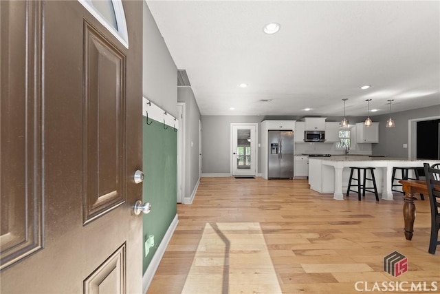 entryway featuring light wood-type flooring, baseboards, and recessed lighting