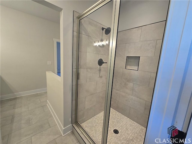 full bath featuring a shower stall, baseboards, and tile patterned floors