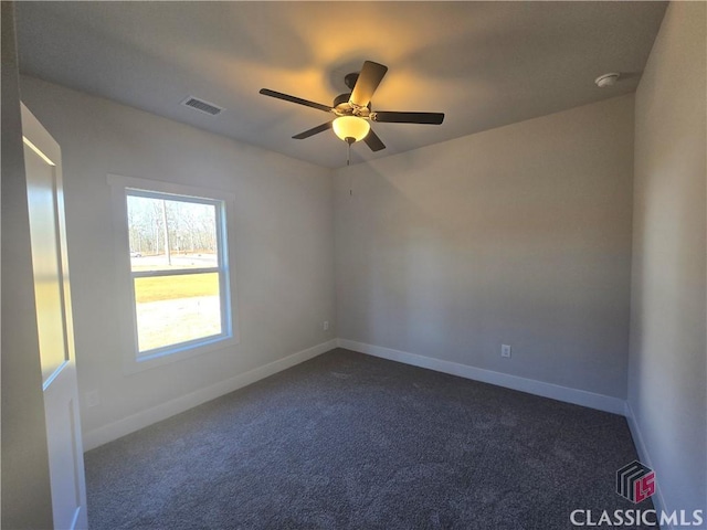 empty room with a ceiling fan, visible vents, dark carpet, and baseboards