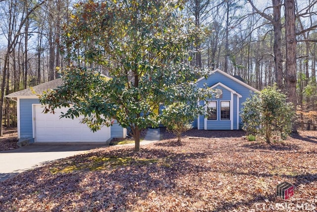 obstructed view of property featuring an attached garage and concrete driveway