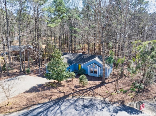 view of front of home featuring a forest view