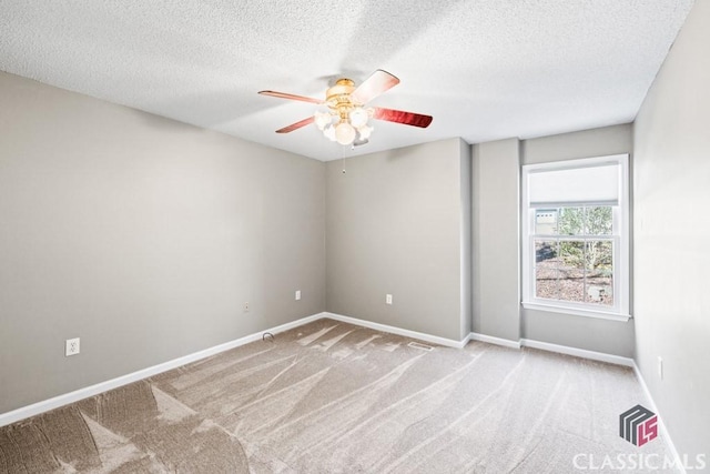 carpeted empty room with a textured ceiling, ceiling fan, and baseboards