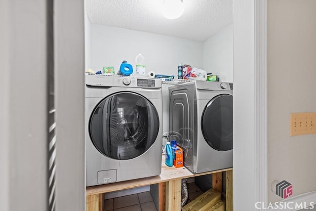 clothes washing area featuring a textured ceiling and washer and dryer