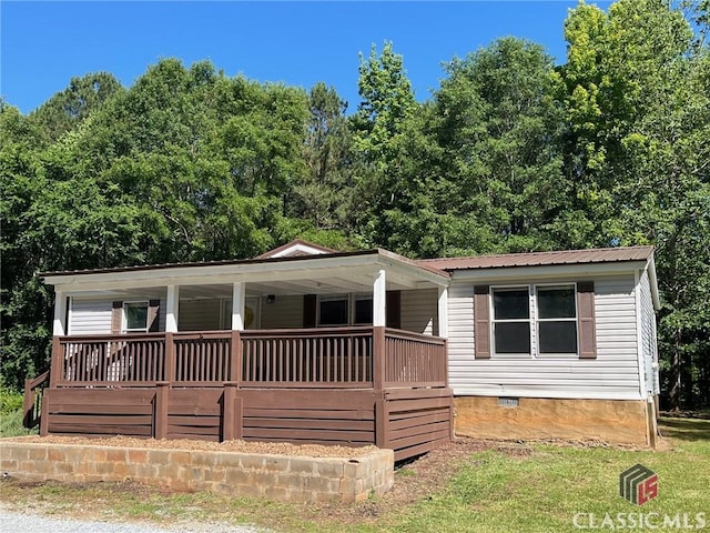 view of front facade featuring a porch, crawl space, and metal roof