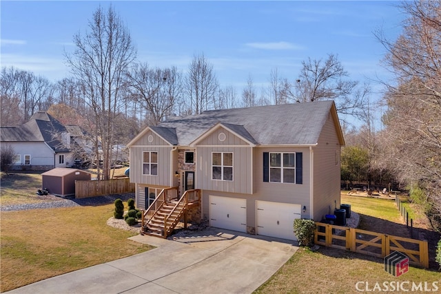 bi-level home with driveway, a front lawn, an attached garage, and fence