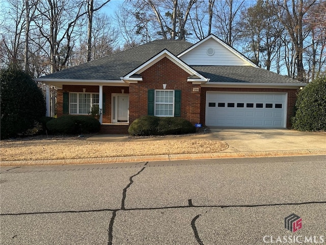 view of front of property with a garage, brick siding, driveway, and a shingled roof