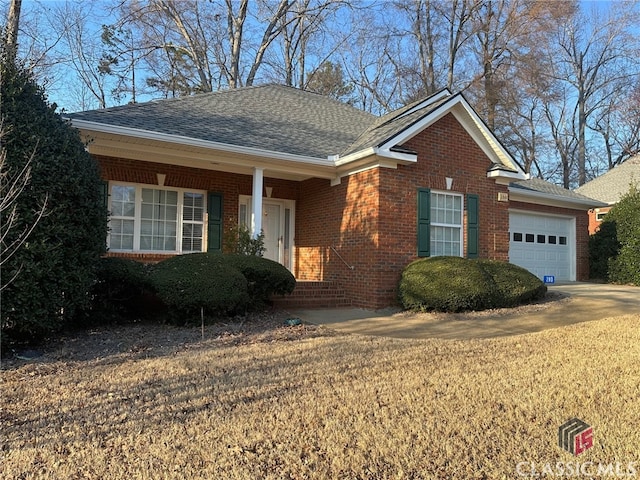 ranch-style house with a garage, brick siding, and a shingled roof